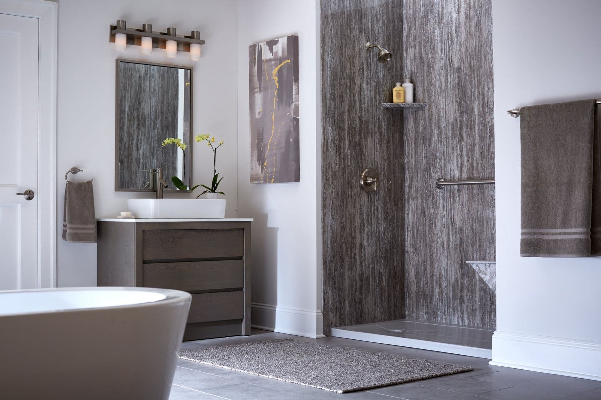 Modern bathroom with freestanding tub, wooden vanity with vessel sink, walk-in shower with gray tile, and chrome fixtures.